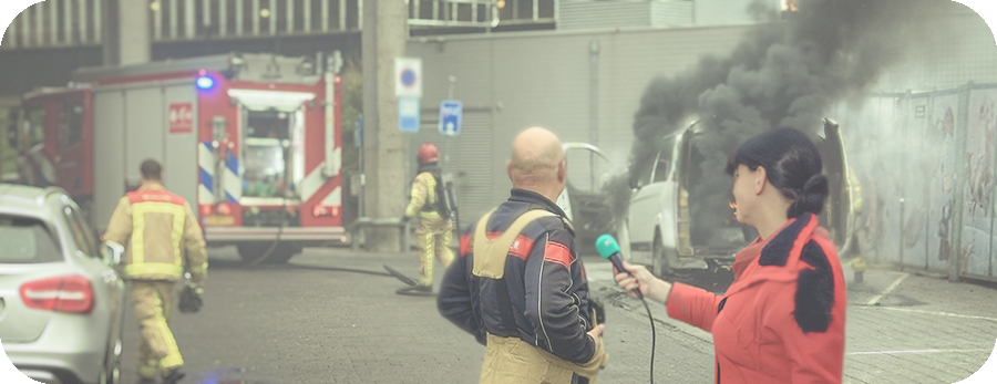 Reporter Mel intervieuwd de Commandant van de Brandweer in Eindhoven bij een autobrand bij station Eindhoven